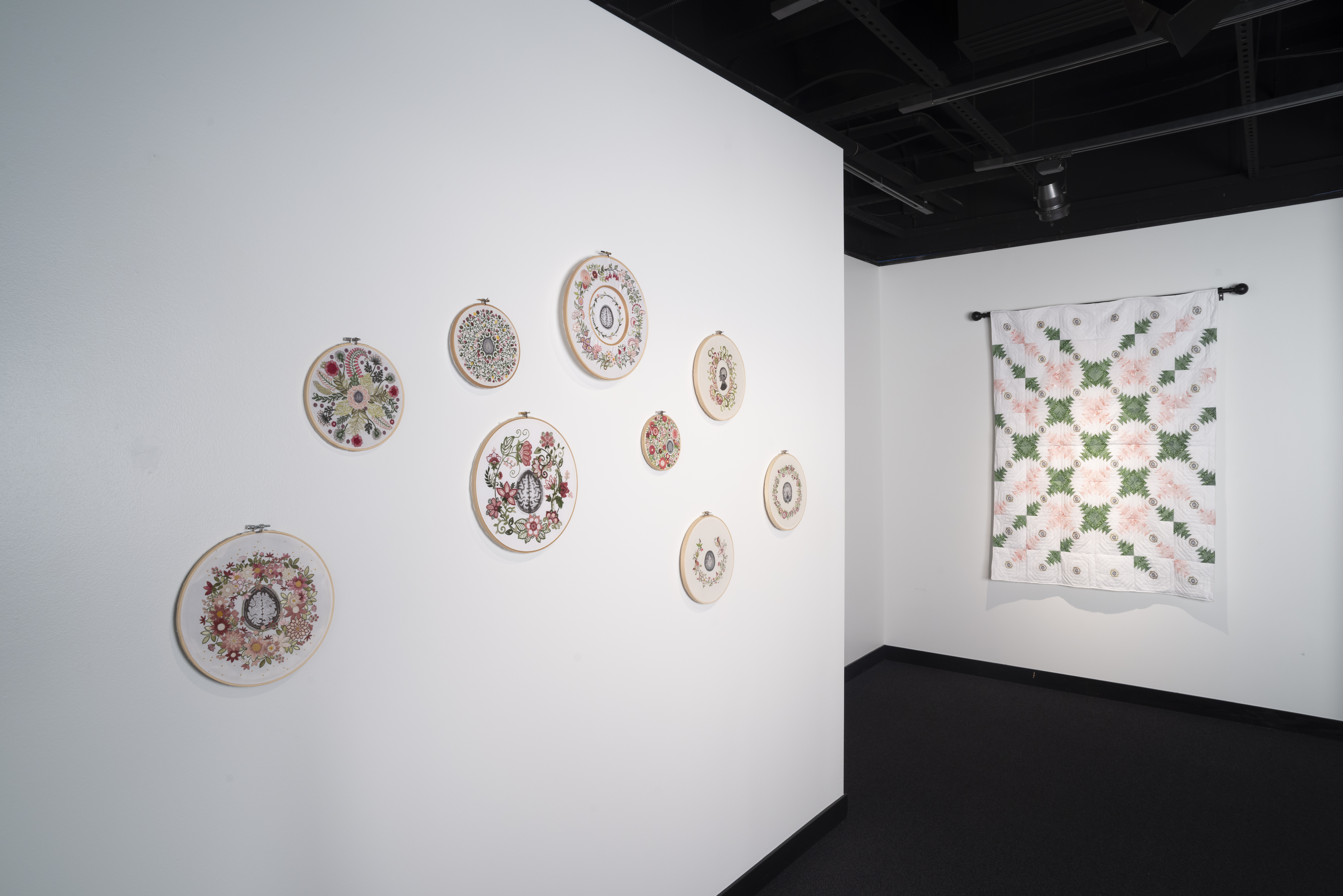 A quilt and several embroidery pieces